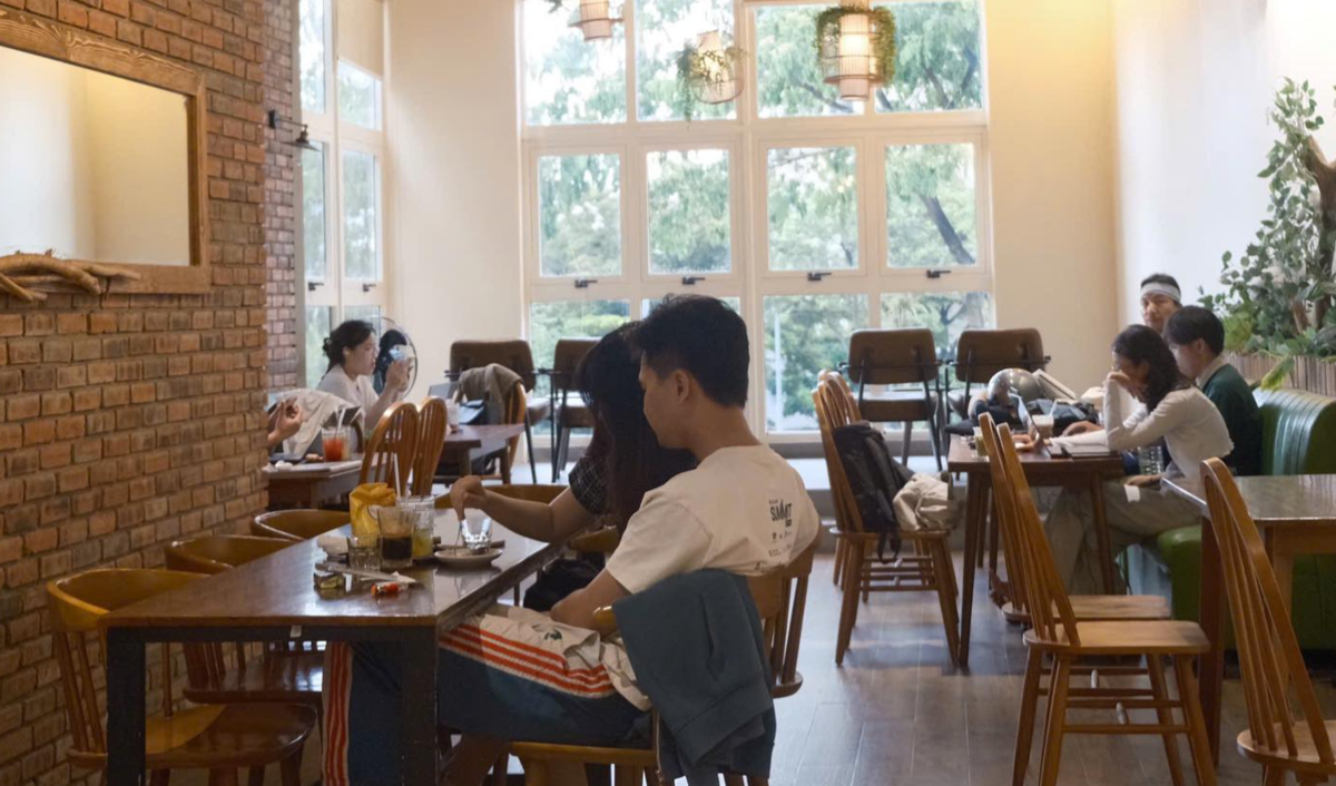 Si:mê Café có ánh sáng tự nhiên len qua các ô cửa sổ, mùi cà phê thơm nồng hòa quyện với hương gỗ ấm áp
