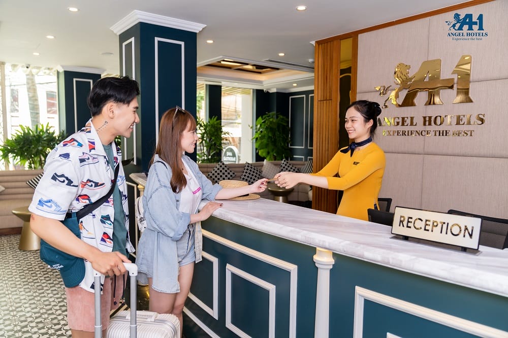Du khách làm thủ tục check-in tại quầy lễ tân Angel Hotels Đà Nẵng.
